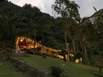a house on a hill with lights on it at FINCA HOTEL CARMONIA DEL BOSQUE in Venecia