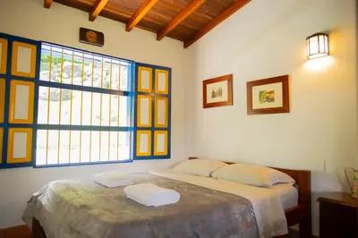 a bedroom with a bed and a large window at FINCA HOTEL CARMONIA DEL BOSQUE in Venecia