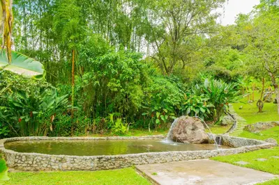 a pond in the middle of a garden at FINCA HOTEL CARMONIA DEL BOSQUE in Venecia