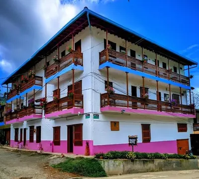 a pink and white building with balconies on it at Hotel Macao in Jardin