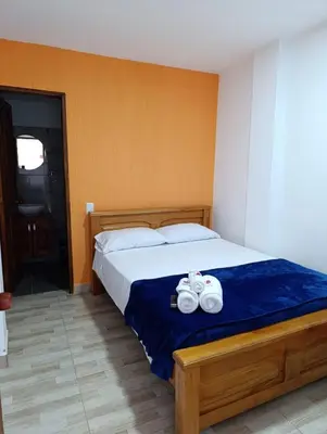a bedroom with a bed with two towels on it at Hotel Macao in Jardin