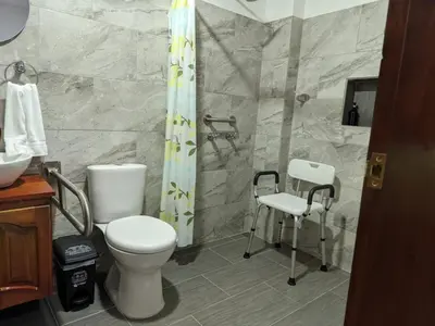 a bathroom with a toilet and a shower at Hotel Macao in Jardin