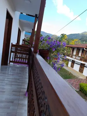 a balcony of a house with purple flowers at Hotel Macao in Jardin