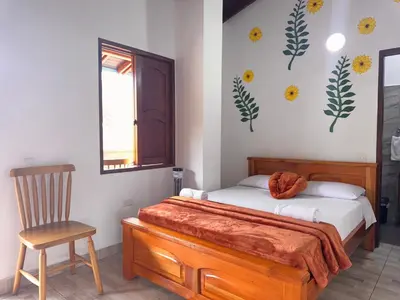 a bedroom with a bed and a chair in it at Hotel Macao in Jardin