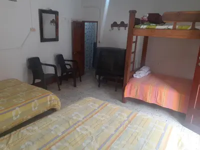 a bedroom with two bunk beds and a television at Hostal La Comedia in Jardin