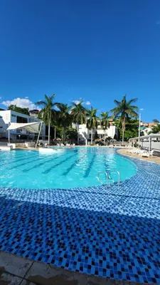 a swimming pool with a pair of glasses on it at Apartasol Ciudadela Santafe - Santa Fe de Antioquia in Santa Fe de Antioquia
