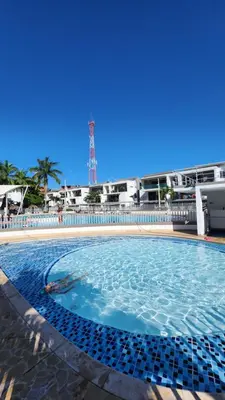 a large swimming pool with blue water in front of a building at Apartasol Ciudadela Santafe - Santa Fe de Antioquia in Santa Fe de Antioquia