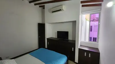 a small bedroom with a bed and a window at Apartasol Ciudadela Santafe - Santa Fe de Antioquia in Santa Fe de Antioquia