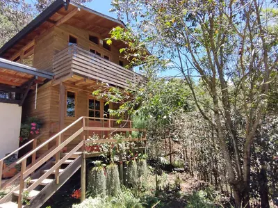 a log house with a garden in front of it at La Cabaña de Huckleberry in El Retiro