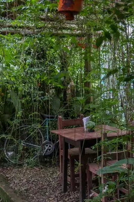 a table and chairs in a garden with plants at Finca Los Abuelos - La Planta in Concepción