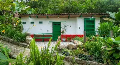 a house with green doors and a bench in a garden at Finca Los Abuelos - La Planta in Concepción