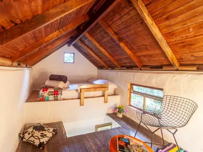 a bedroom in a house with a bed and a chair at Finca Los Abuelos - La Planta in Concepción