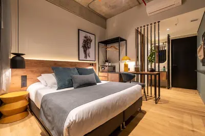 a bedroom with a large bed and a desk at Hashtag 98 Hotel By Jalo in Medellín