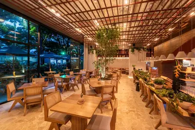 a restaurant with tables and chairs and large windows at Hashtag 98 Hotel By Jalo in Medellín