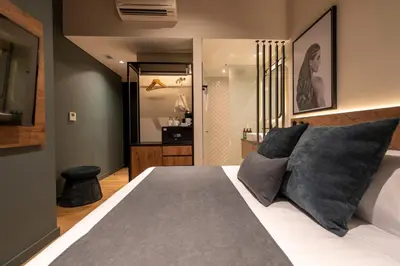 a bedroom with a large bed with gray pillows at Hashtag 98 Hotel By Jalo in Medellín