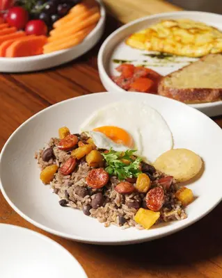 a plate of food with an egg on a table at Hashtag 98 Hotel By Jalo in Medellín