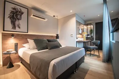 a bedroom with a bed and a desk in a room at Hashtag 98 Hotel By Jalo in Medellín