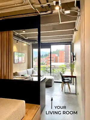 a living room with a bed and a living room with a living room at Beminimal Hotel in Medellín