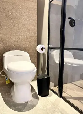 a bathroom with a white toilet and a shower at Beminimal Hotel in Medellín