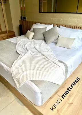 a large bed with white blankets and pillows on it at Beminimal Hotel in Medellín