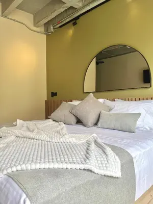a large white bed with a large mirror on the wall at Beminimal Hotel in Medellín