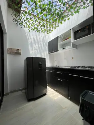 a kitchen with a black refrigerator and a ceiling at APARTAMENTO AMOBLADO SECTOR LAURELES-ESTADIO hasta 8 personas - Londres in Medellín