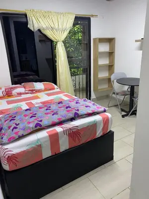 a bedroom with a bed and a table and a window at HABITACION AMOBLADA SECTOR LAURELES-ESTADIO hasta 3 personas Santorini in Medellín