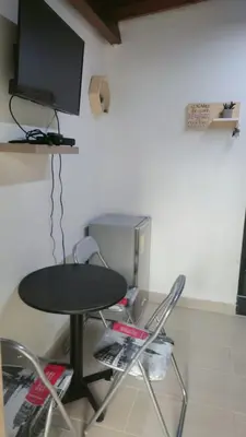 a table and chairs with a television on a wall at HABITACION AMOBLADA SECTOR LAURELES-ESTADIO hasta 3 personas Santorini in Medellín