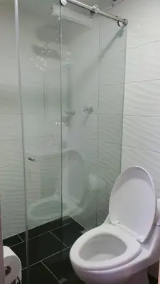 a bathroom with a toilet and a glass shower at HABITACION AMOBLADA SECTOR LAURELES-ESTADIO hasta 3 personas Santorini in Medellín