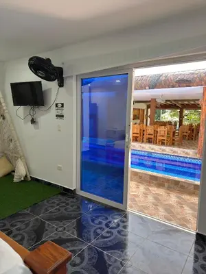 a room with a sliding glass door leading to a swimming pool at Eco hotel el bosque in Doradal