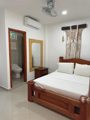 a bedroom with a bed and a toilet and a mirror at Eco hotel el bosque in Doradal