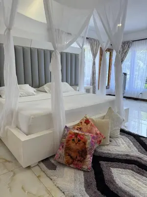 a bedroom with a white bed with a cat pillow at Eco hotel el bosque in Doradal