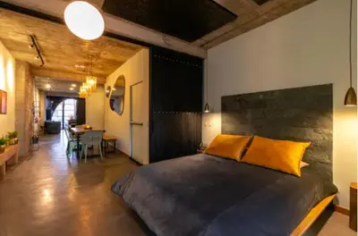a bedroom with a large bed and a dining room at Nido Sky in Medellín