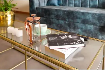 a glass table with a book and a vase on it at Nido Sky in Medellín