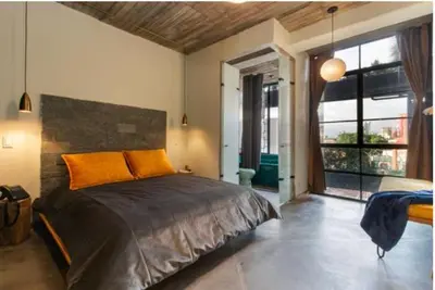 a bedroom with a large bed with an orange pillow at Nido Sky in Medellín