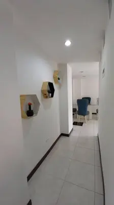 a hallway of an office with white walls and blue chairs at Apartamento remodelado enLaureles 300mbps internet in Medellín