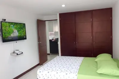a bedroom with a bed and a tv on a wall at Apartamento remodelado enLaureles 300mbps internet in Medellín