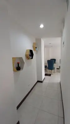 an empty hallway with white walls and blue chairs at Apartamento remodelado enLaureles 300mbps internet in Medellín