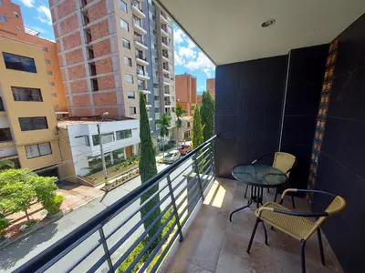 a balcony with a table and chairs and a view of a city at Apartamento remodelado enLaureles 300mbps internet in Medellín