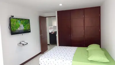 a bedroom with a bed and a tv on a wall at Apartamento remodelado enLaureles 300mbps internet in Medellín