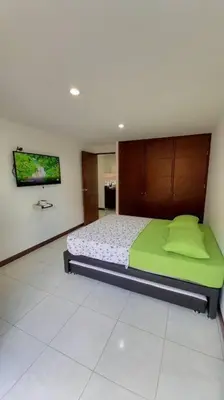 a bedroom with a bed and a tv on the wall at Apartamento remodelado enLaureles 300mbps internet in Medellín
