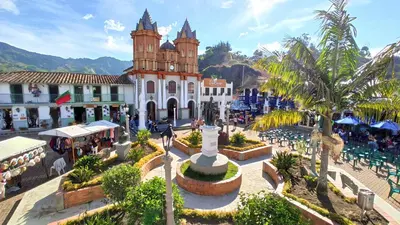 a building with a clock tower in the middle of a town at Finca Palma de Coco, Municipio de el Peñol Antioquia in El Peñol