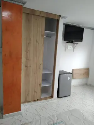 a room with a closet with a tv and a door at Hotel Kariary in Puerto Boyacá