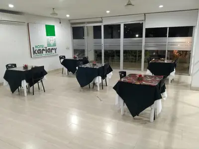 a group of tables and chairs in a room at Hotel Kariary in Puerto Boyacá