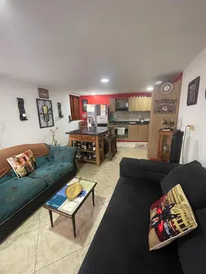 a living room with two couches and a kitchen at Villa Chela, Hermosa casa de descanso, Venecia Antioquia in Venecia