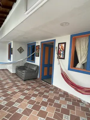 a living room with a couch and blue doors at Villa Chela, Hermosa casa de descanso, Venecia Antioquia in Venecia