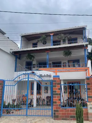 a house with a blue gate in front of it at Villa Chela, Hermosa casa de descanso, Venecia Antioquia in Venecia