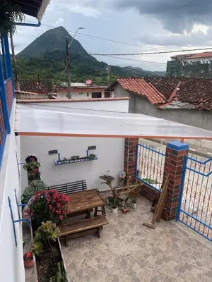 a patio with a table and a bench on a balcony at Villa Chela, Hermosa casa de descanso, Venecia Antioquia in Venecia