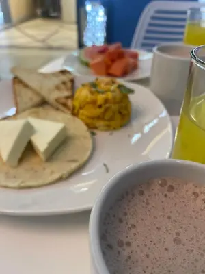 a plate of food with cheese and fruit on a table at Brana by Bernalo Hotels in Medellín