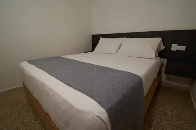 a bedroom with a large bed with a black headboard at Brana by Bernalo Hotels in Medellín